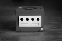 white and black Nintendo GameCube console on gray surface